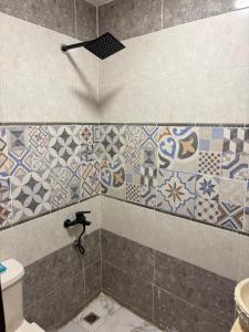 ein Bad mit Dusche, WC und Fliesen in der Unterkunft 4 Pyramids INN in Kairo