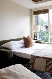 two beds in a room with a window at Misty Mountain- Premium 2 Bedroom Mountain View in Canmore