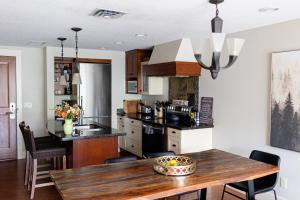 a kitchen with a wooden table and a dining room at Misty Mountain- Premium 2 Bedroom Mountain View in Canmore