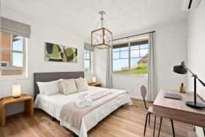 ein weißes Schlafzimmer mit einem Bett und einem Schreibtisch in der Unterkunft Marbella Lane - 2 master suites MTOcean Views in Makaha Valley + 80 Fotos