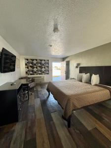 a bedroom with a bed and a desk and a television at Kermit Inn in Kermit
