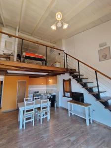 a living room with a staircase and a table and chairs at Apart Sorrento in Santa Teresita