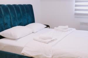 ein weißes Bett mit weißen Kissen und einem blauen Kopfteil in der Unterkunft Jahorinska Vila in Jahorina