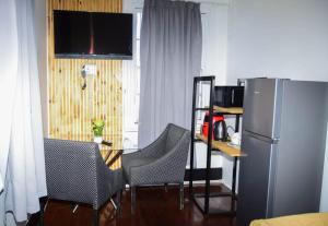 Una cocina con refrigerador y una mesa con sillas. en HAPPY HOME Guest house, en Gqeberha