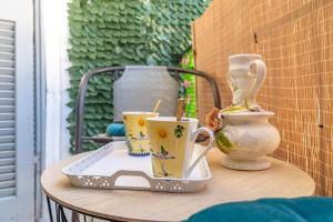 a table with three cups and vases on it at Verdea Suite in Ágios Rókkos