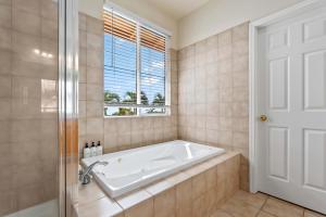 カポレイにあるMarbella Lane Posh 4BR with Spectacular Viewsの窓のある浴室の浴槽