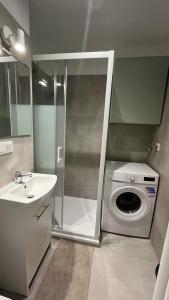 een badkamer met een wasmachine en een wastafel bij Rooms in Warsaw - G5 in Warschau