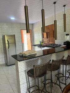 Serra dos MatõesにあるCasa para temporada - Dona Nidiaのキッチン(椅子と冷蔵庫付きのカウンター付)