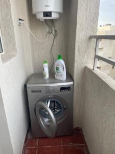 uma máquina de lavar roupa com duas garrafas em cima em Farah airport résidence em Tânger mais 2 fotografias