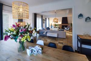 a living room with a vase of flowers on a table at Vakantiehuis Elisa in Alken