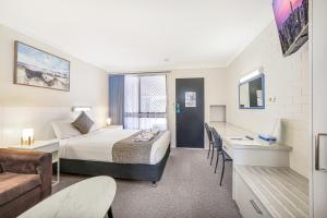 Acacia Motor Inn في بوندابرج: غرفة فندق بها سرير وأريكة +41 صورة