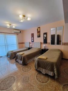 a hotel room with three beds in a room at Apart Sorrento in Santa Teresita