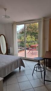 a bedroom with a bed and a balcony with a table at L'appartement d'Ananda in Villefranche-de-Rouergue