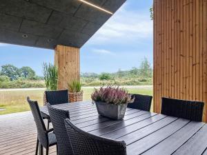 een houten tafel met stoelen en een potplant op een terras bij 5 star holiday home in Skals in Skals