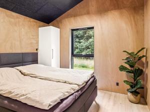 a bedroom with a bed and a potted plant at 5 star holiday home in Skals in Skals +25 photos