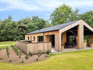 a large wooden building with a grill in a field at 5 star holiday home in Skals in Skals