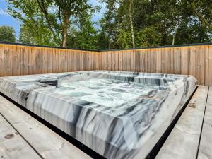 a hot tub sitting next to a wooden fence at 5 star holiday home in Skals in Skals