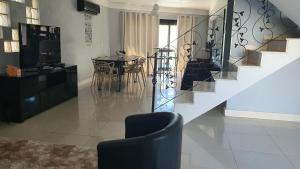 a living room with a staircase and a table and chairs at Casa-Ampla Porto Alegre-RS in Porto Alegre