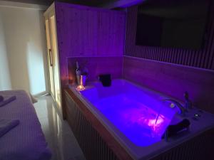 a purple tub in a room with a sink at Jacuzzi & Sauna Edy room - city center in Zagreb +59 photos