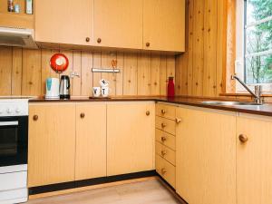 a kitchen with wooden cabinets and a sink at 4 person holiday home in Ansager in Ansager
