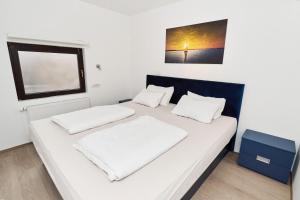 een slaapkamer met twee bedden met witte lakens en een raam bij Matic Murgle Atrium Apartment in Ljubljana