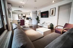 een woonkamer met een bank en een tafel bij Matic Murgle Atrium Apartment in Ljubljana