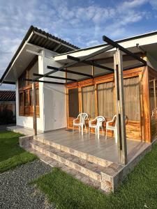 ein Haus mit einer Terrasse mit Stühlen darauf in der Unterkunft Eco cabañas montana in El Cerrito