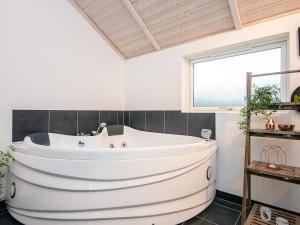 a large white tub in a bathroom with a window at 5 star holiday home in Ansager in Ansager +43 photos
