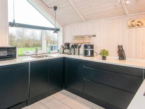 a kitchen with black cabinets and a sink at 5 star holiday home in Ansager in Ansager
