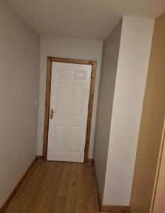 an empty room with a white door and a wooden floor at holiday in Waterford