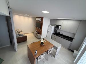 a living room with a table and a kitchen at Studio Premium com lazer completo , ótima localização in Goiânia