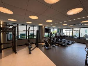 a gym with several treadmills and ellipticals and windows at Studio Premium com lazer completo , ótima localização in Goiânia