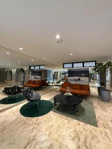 a living room with couches and chairs and tables at Studio Premium com lazer completo , ótima localização in Goiânia +33 photos