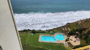 an aerial view of a swimming pool and the ocean at CostaQuilen Departamento in Puchuncaví