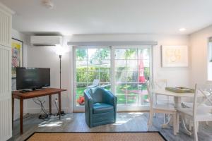 a living room with a television and a table with a chair at East End Condo w Beach Access in Provincetown
