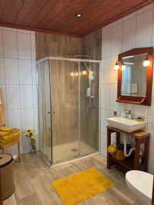 a bathroom with a shower and a sink at Refúgio das Pedreiras in Praia da Vitória +20 photos