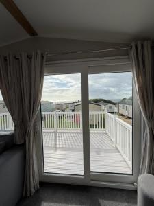 een glazen schuifdeur met uitzicht op een balkon bij Luxury 3 bed sleeps 8 caravan with sea view in Exmouth +3 foto's