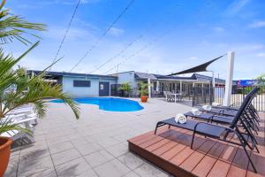 Acacia Motor Inn في بوندابرج: فناء مع مقعد ومسبح