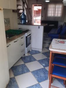 a kitchen with white cabinets and blue and white tiles at Flat I - 50 Metros da Praia in Caraguatatuba