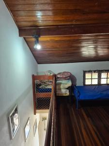 a room with two bunk beds and a wooden ceiling at Flat I - 50 Metros da Praia in Caraguatatuba