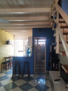 a kitchen with a blue counter and stools at Flat I - 50 Metros da Praia in Caraguatatuba