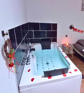 a bath tub in a room with a couch at Balnéo privée, Cinéma, Fibre & Patio in Tourcoing