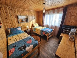 圣地亚哥Hostal Sol y Luna - Descanso a 10 min del aeropuerto & Desayuno Incluido的小木屋内一间卧室,配有两张床