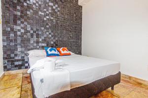 a bed in a room with a brick wall at Hostel Wafeh Fleming in Belo Horizonte +11 photos