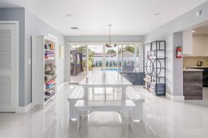 una sala da pranzo bianca con tavolo e cucina di 4 BR home with private pool a Fort Lauderdale