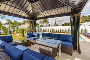 patio con divani blu e tavolo di 4 BR home with private pool a Fort Lauderdale