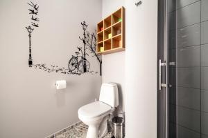baño con aseo y pegatina para bicicletas en la pared en Park Plus APART, en Leópolis 30 fotos más