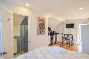 普罗温斯敦East End Condo w Beach Access的一间带一张床和淋浴的卧室以及一间厨房