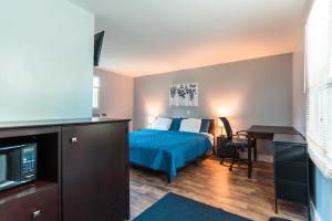 ein Hotelzimmer mit Bett und Schreibtisch in der Unterkunft Nest Inn in Watertown