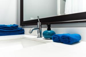 Ein Waschbecken im Badezimmer mit einem blauen Handtuch neben einem Wasserhahn in der Unterkunft Nest Inn in Watertown